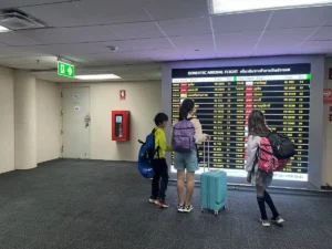 子連れ海外旅行で空港到着後にフライト案内を見る家族｜子供連れ海外旅行の流れ